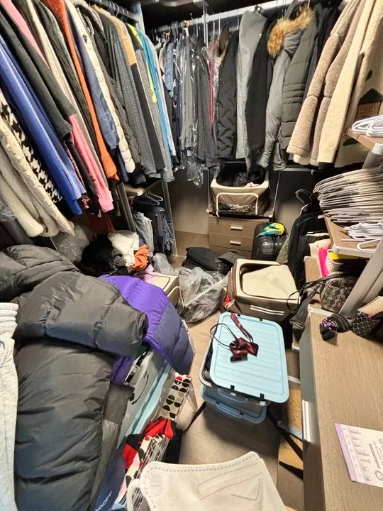 드레스룸 바닥의 의류와 보관 상자 상세 구도